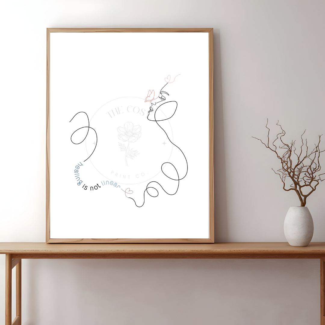 A minimalist print with the phrase “Healing isn’t linear” and a single-line drawing of a face and butterfly, in soft, calming tones.