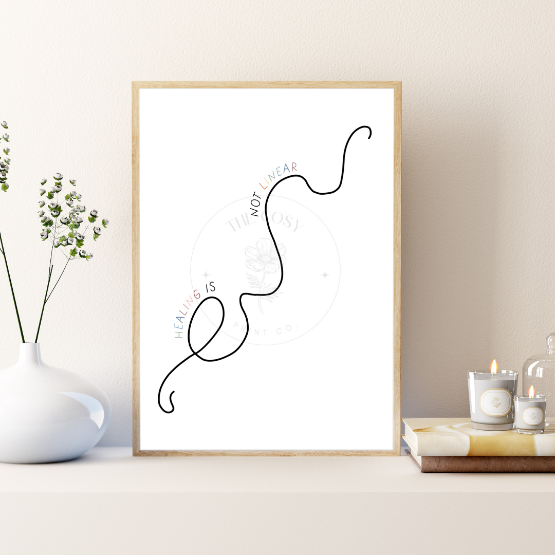 A minimalist print with the phrase “Healing isn’t linear” in calming script, surrounded by soft, neutral tones and gentle shapes.
