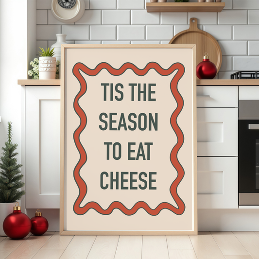 Funny Christmas print reading “’Tis the Season to Eat Cheese” in festive hand-written text.