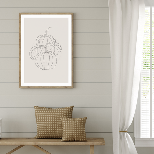 Minimalist hand-drawn pumpkin wall art on a greige background with subtle autumn tones.